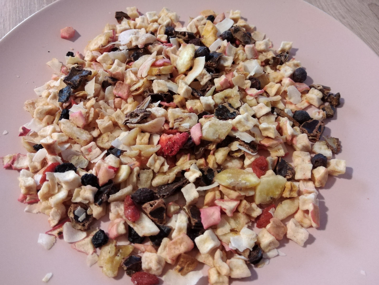 Bunte Fischpaella Trockenfutter auf rosa Teller